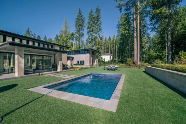 a pool in a yard with trees in the background